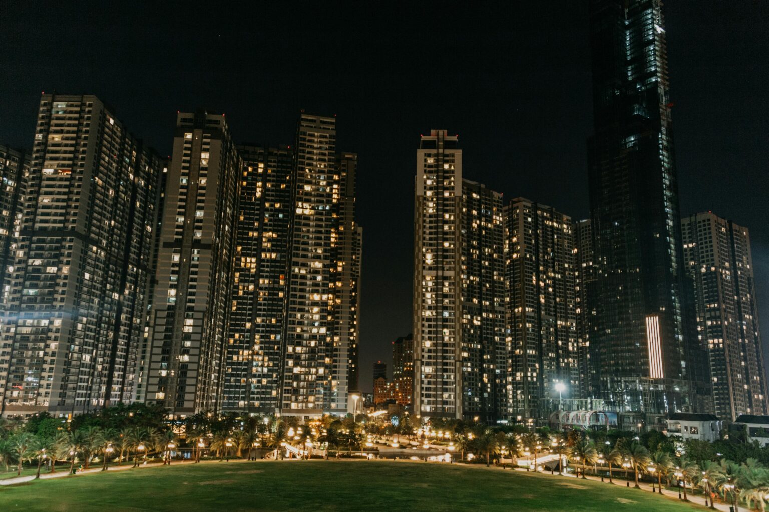 A vibrant night cityscape featuring modern skyscrapers illuminated against the night sky.